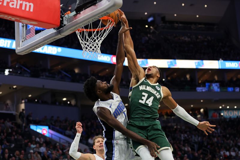 MILWAUKEE, WISCONSIN - DECEMBER 21: Giannis Antetokounmpo #34 of the Milwaukee Bucks is fouled by Jonathan Isaac #1 of the Orlando Magic during the first half of a game at Fiserv Forum on December 21, 2023 in Milwaukee, Wisconsin. NOTE TO USER: User expressly acknowledges and agrees that, by downloading and or using this photograph, User is consenting to the terms and conditions of the Getty Images License Agreement. (Photo by Stacy Revere/Getty Images)