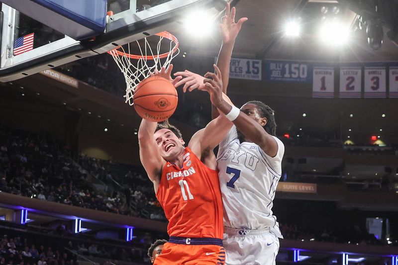 Dec 9, 2025; New York, New York, USA;  Clemson Tigers forward Nick Davidson (11) grabs a rebound from BYU Cougars forward Khadim Mboup (7) in the first half at Madison Square Garden. Mandatory Credit: Wendell Cruz-Imagn Images