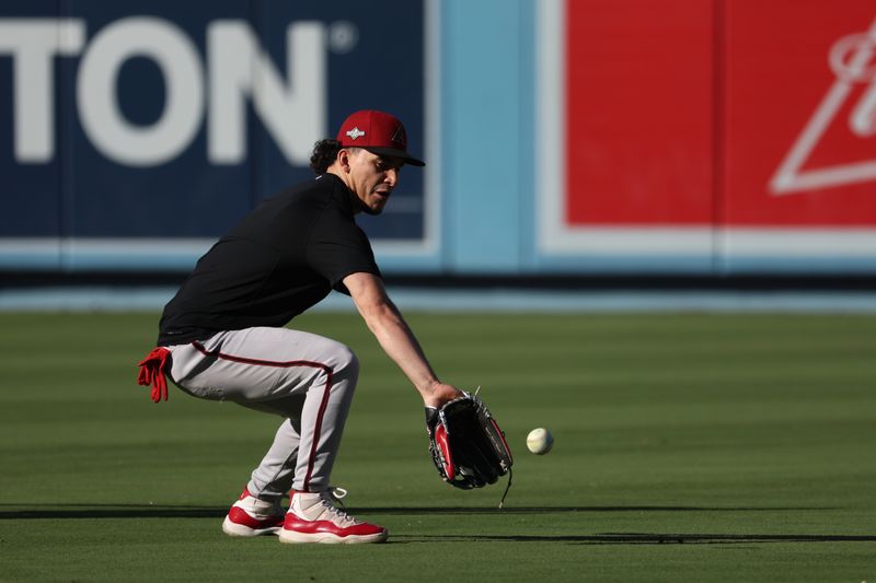 Oct 9, 2023; Los Angeles, California, USA; Arizona Diamondbacks center fielder Alek Thomas (5) fields a ball before game two of the NLDS between the Los Angeles Dodgers and the Arizona Diamondbacks for the 2023 MLB playoffs at Dodger Stadium. Mandatory Credit: Kiyoshi Mio-USA TODAY Sports