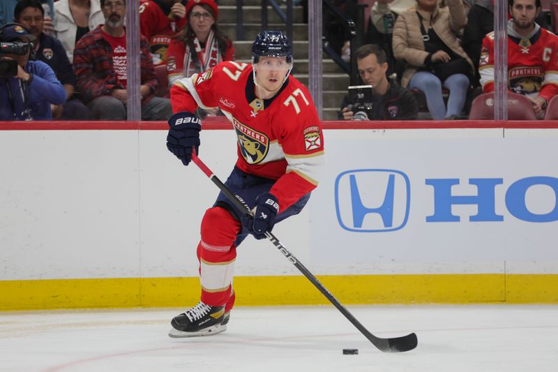 Feb 6, 2024; Sunrise, Florida, USA; Florida Panthers defenseman Niko Mikkola (77) moves the puck against the Philadelphia Flyers during the first period at Amerant Bank Arena. Mandatory Credit: Sam Navarro-USA TODAY Sports