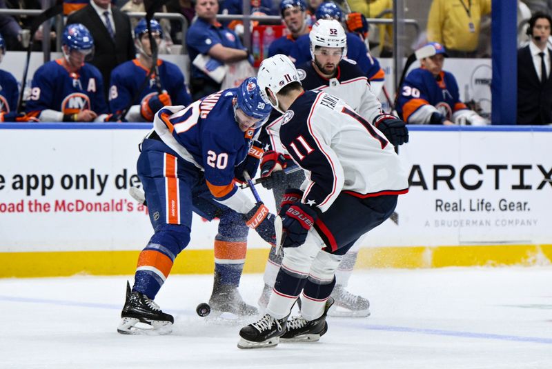 Dec 7, 2023; Elmont, New York, USA; New York Islanders right wing Hudson Fasching (20) tries to gain control of the puck against Columbus Blue Jackets center Adam Fantilli (11) during the first period at UBS Arena. Mandatory Credit: John Jones-USA TODAY Sports