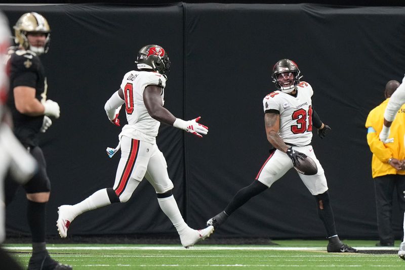 Tampa Bay Buccaneers safety Antoine Winfield Jr. (31) smiles after collecting a fumble and running for a touchdown during an NFL football game against the New Orleans Saints, Sunday, October. 13, 2024, in New Orleans, LA. (AP Photo/Peter Joneleit)