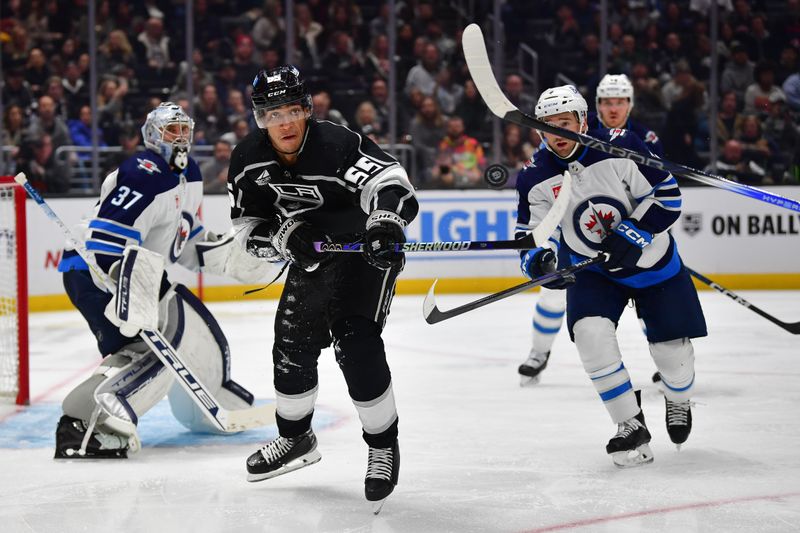 Dec 13, 2023; Los Angeles, California, USA; Los Angeles Kings right wing Quinton Byfield (55) plays for the puck against the Winnipeg Jets during the second period at Crypto.com Arena. Mandatory Credit: Gary A. Vasquez-USA TODAY Sports