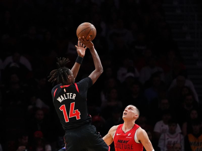 MIAMI, FLORIDA - DECEMBER 12: Ja'Kobe Walter #14 of the Toronto Raptors goes up for a shot against Tyler Herro #14 of the Miami Heat during the second quarter at Kaseya Center on December 12, 2024 in Miami, Florida. NOTE TO USER: User expressly acknowledges and agrees that, by downloading and or using this Photograph, user is consenting to the terms and conditions of the Getty Images License Agreement. (Photo by Rich Storry/Getty Images)