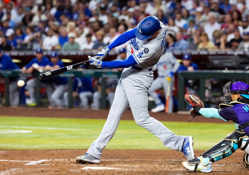 May 9, 2025; Phoenix, Arizona, USA; Los Angeles Dodgers first baseman Freddie Freeman hits a double in the third inning against the Arizona Diamondbacks at Chase Field. Mandatory Credit: Mark J. Rebilas-Imagn Images