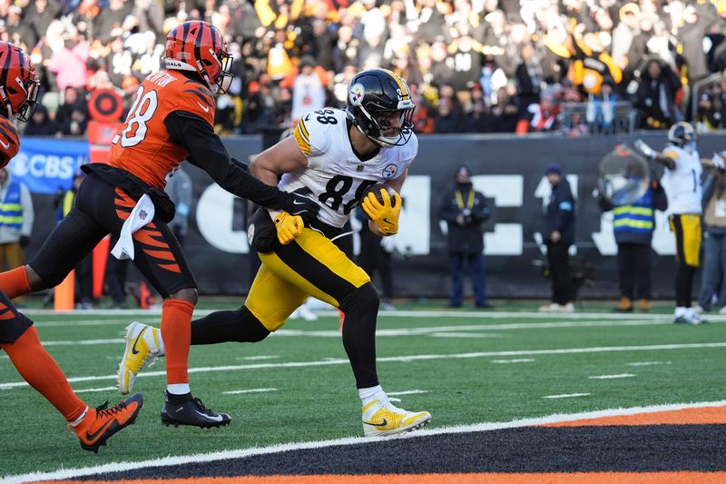 Pittsburgh Steelers tight end Pat Freiermuth, right, scores a touchdown ahead of Cincinnati Bengals cornerback Josh Newton (28) during the second half of an NFL football game Sunday, Dec. 1, 2024, in Cincinnati. (AP Photo/Joshua A. Bickel)