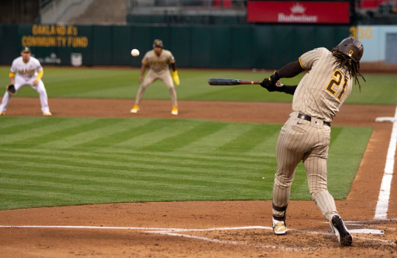 Sep 15, 2023; Oakland, California, USA; San Diego Padres right fielder Fernando Tatis Jr. (21) connects for a two-RBI single against the Oakland Athletics during the second inning at Oakland-Alameda County Coliseum. Players from both team wore number 21 in honor of the late Roberto Clemente. Mandatory Credit: D. Ross Cameron-USA TODAY Sports