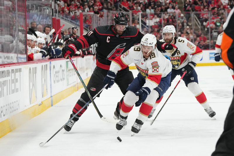 May 22, 2025; Raleigh, North Carolina, USA;  Florida Panthers forward Matthew Tkachuk (19) battles for the puck against Carolina Hurricanes forward Jordan Staal (11) during the first period in game two of the Eastern Conference Final of the 2025 Stanley Cup Playoffs at Lenovo Center. Mandatory Credit: James Guillory-Imagn Images