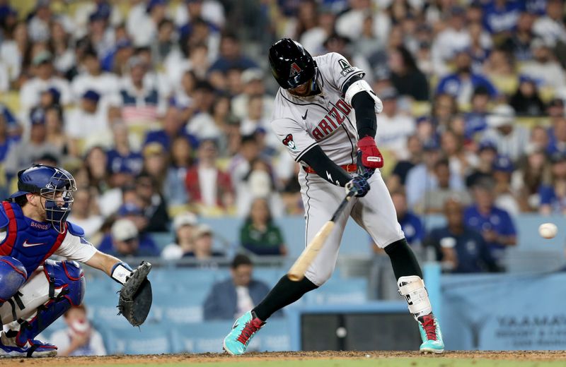 Jul 4, 2024; Los Angeles, California, USA; Arizona Diamondbacks outfielder Lourdes Gurriel Jr. (12) hits a two-RBI single during the ninth inning against the Los Angeles Dodgers at Dodger Stadium. Mandatory Credit: Jason Parkhurst-USA TODAY Sports