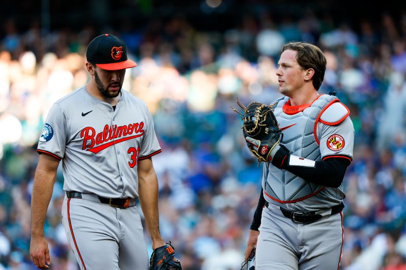 Jul 2, 2024; Seattle, Washington, USA; Baltimore Orioles starting pitcher Grayson Rodriguez (30) and catcher Adley Rutschman (35) talk while walking back to the dugout following the first inning at T-Mobile Park. Mandatory Credit: Joe Nicholson-USA TODAY Sports