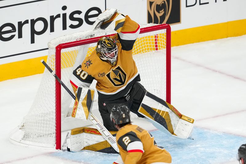 Nov 11, 2024; Las Vegas, Nevada, USA; Vegas Golden Knights goaltender Akira Schmid (40) attempts to glove a shot by the Carolina Hurricanes during the third period at T-Mobile Arena. Mandatory Credit: Stephen R. Sylvanie-Imagn Images