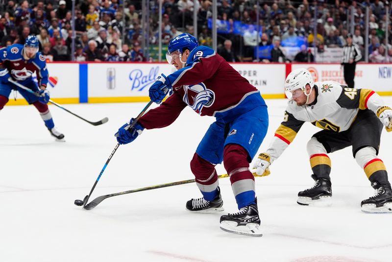 Apr 8, 2025; Denver, Colorado, USA; Colorado Avalanche center Nathan MacKinnon (29) shoots the puck as Vegas Golden Knights center Ivan Barbashev (49) defends in overtime at Ball Arena. Mandatory Credit: Ron Chenoy-Imagn Images