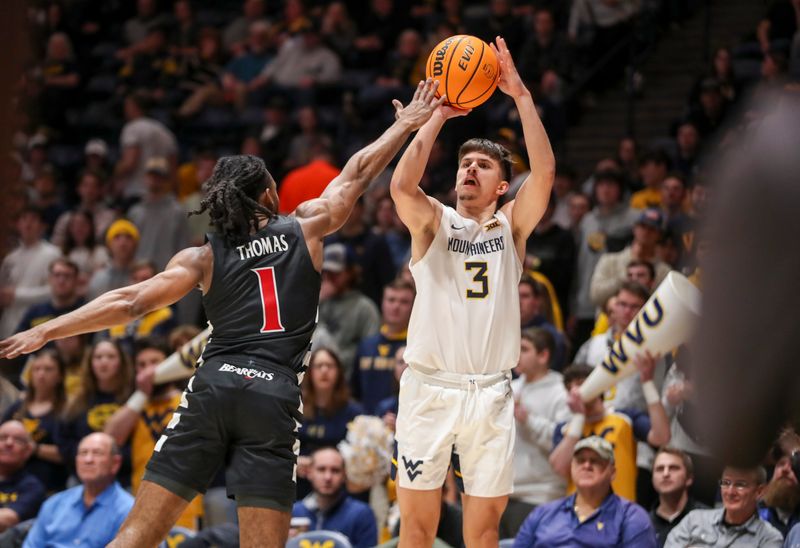 Jan 31, 2024; Morgantown, West Virginia, USA; West Virginia Mountaineers guard Kerr Kriisa (3) shoots a three pointer over Cincinnati Bearcats forward Kalu Ezikpe (1) during the second half at WVU Coliseum. Mandatory Credit: Ben Queen-USA TODAY Sports