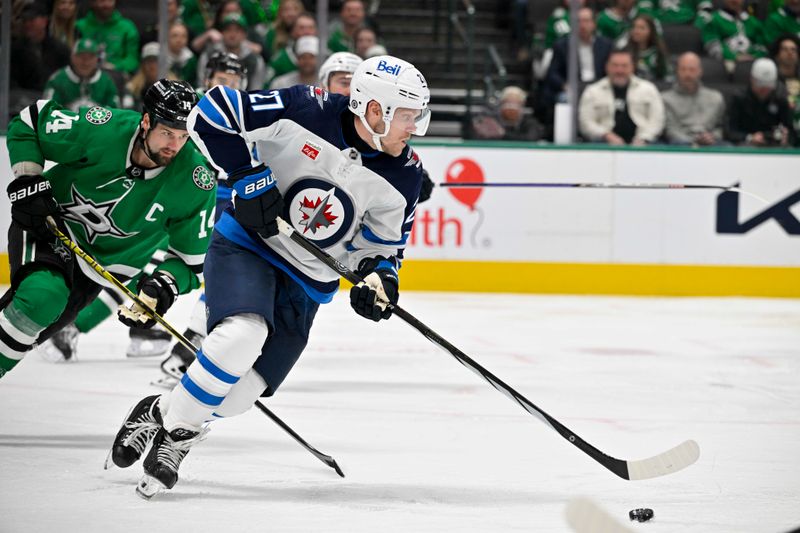 Feb 29, 2024; Dallas, Texas, USA; Winnipeg Jets left wing Nikolaj Ehlers (27) brings the puck out of the Jets zone as Dallas Stars left wing Jamie Benn (14) chases during the second period at the American Airlines Center. Mandatory Credit: Jerome Miron-USA TODAY Sports
