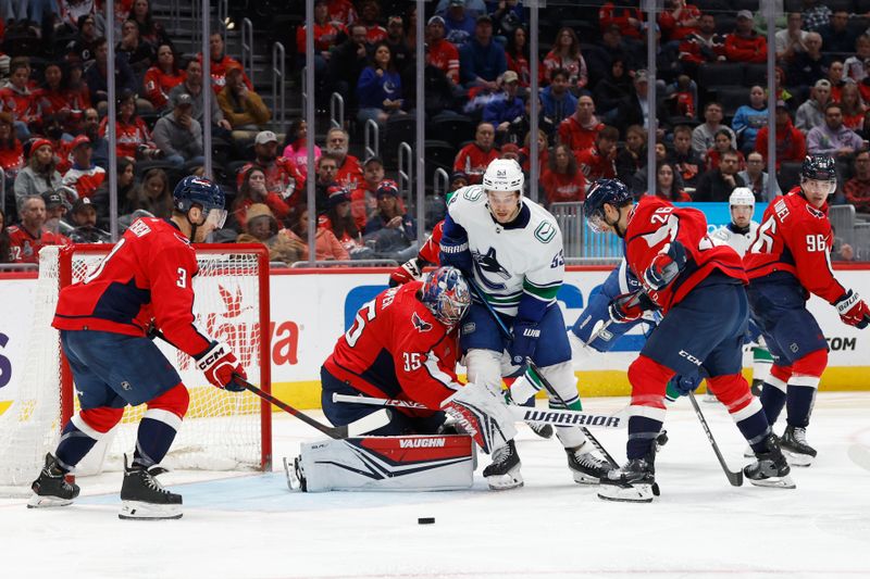 Feb 11, 2024; Washington, District of Columbia, USA; Vancouver Canucks center Teddy Blueger (53), Washington Capitals right wing Nic Dowd (26), and Capitals defenseman Nick Jensen (3) battle for the puck in front of Capitals goaltender Darcy Kuemper (35) in the second period at Capital One Arena. Mandatory Credit: Geoff Burke-USA TODAY Sports