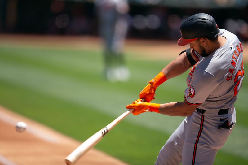 Jul 7, 2024; Oakland, California, USA; Baltimore Orioles right fielder Anthony Santander (25) hits a solo home run against the Oakland Athletics during the first inning at Oakland-Alameda County Coliseum. Mandatory Credit: D. Ross Cameron-USA TODAY Sports