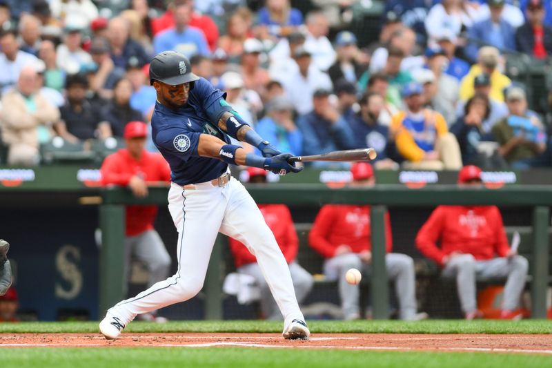 Jul 22, 2024; Seattle, Washington, USA; Seattle Mariners center fielder Victor Robles (10) hits a single against the Los Angeles Angels during the first inning at T-Mobile Park. Mandatory Credit: Steven Bisig-USA TODAY Sports