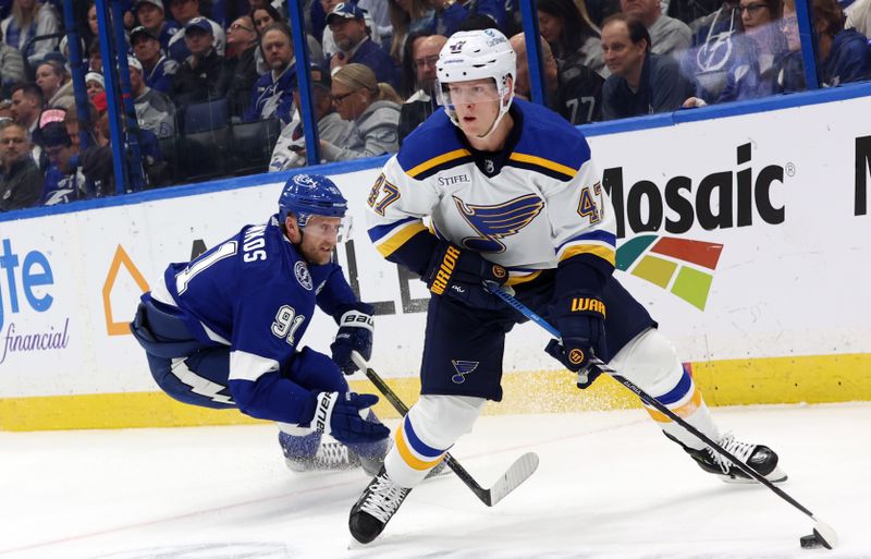 Dec 19, 2023; Tampa, Florida, USA; St. Louis Blues defenseman Torey Krug (47) skates with the puck as Tampa Bay Lightning center Steven Stamkos (91) defends during the first period at Amalie Arena. Mandatory Credit: Kim Klement Neitzel-USA TODAY Sports