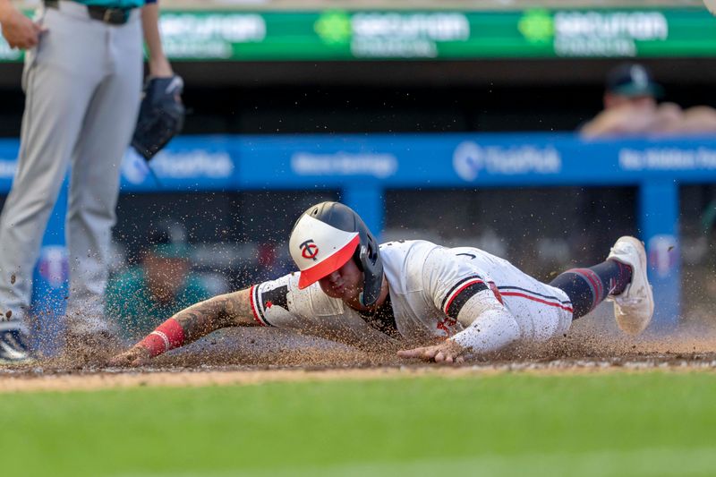 May 8, 2024; Minneapolis, Minnesota, USA; Minnesota Twins third baseman Jose Miranda (64) slides into home plate for a run against the Seattle Mariners in the fourth inning at Target Field. Mandatory Credit: Jesse Johnson-USA TODAY Sports