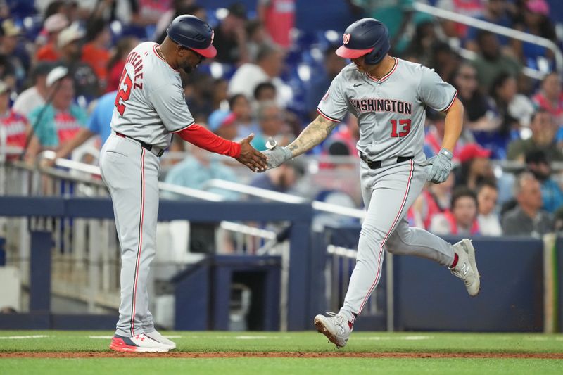 Apr 28, 2024; Miami, Florida, USA;  Washington Nationals designated hitter Nick Senzel (13) is congratulated by third base coach Ricky Gutierrez (12) after hitting a three-run home run against the Miami Marlins in the fifth inning at loanDepot Park. Mandatory Credit: Jim Rassol-USA TODAY Sports