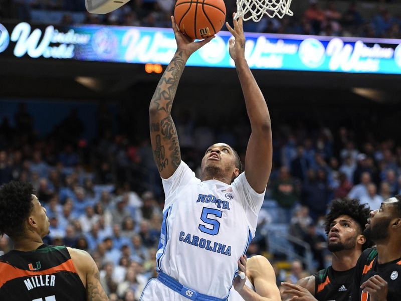 Feb 13, 2023; Chapel Hill, North Carolina, USA; North Carolina Tar Heels forward Armando Bacot (5) shoots as Miami (Fl) Hurricanes guard Jordan Miller (11) defends in the second half at Dean E. Smith Center. Mandatory Credit: Bob Donnan-USA TODAY Sports