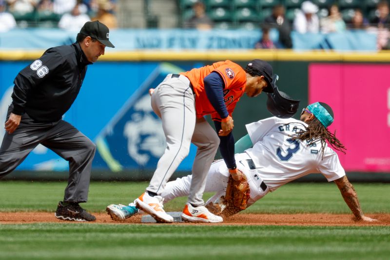 May 30, 2024; Seattle, Washington, USA; Seattle Mariners shortstop J.P. Crawford (3) steals second base before Houston Astros shortstop Jeremy Pena (3) can apply a tag during the first inning at T-Mobile Park. Umpire David Rackley (86) follows the play at left. Mandatory Credit: Joe Nicholson-USA TODAY Sports