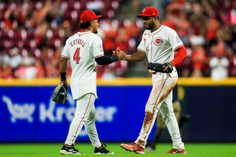 Jul 8, 2024; Cincinnati, Ohio, USA; Cincinnati Reds third baseman Santiago Espinal (4) shakes hands with first baseman Jeimer Candelario (3) after the victory over the Colorado Rockies at Great American Ball Park. Mandatory Credit: Katie Stratman-USA TODAY Sports