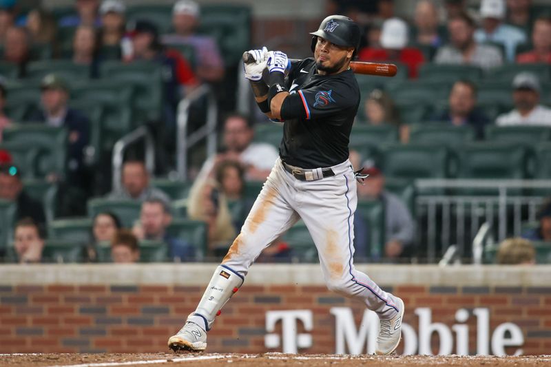 Apr 24, 2024; Atlanta, Georgia, USA; Miami Marlins second baseman Luis Arraez (3) hits a single against the Atlanta Braves in the ninth inning at Truist Park. Mandatory Credit: Brett Davis-USA TODAY Sports