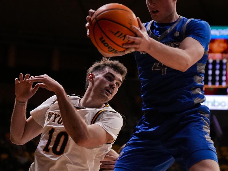 Feb 17, 2023; Laramie, Wyoming, USA; Air Force Falcons guard Carter Murphy (4) controls a rebound against Wyoming Cowboys forward Hunter Thompson (10) during the first half at Arena-Auditorium. Mandatory Credit: Troy Babbitt-USA TODAY Sports