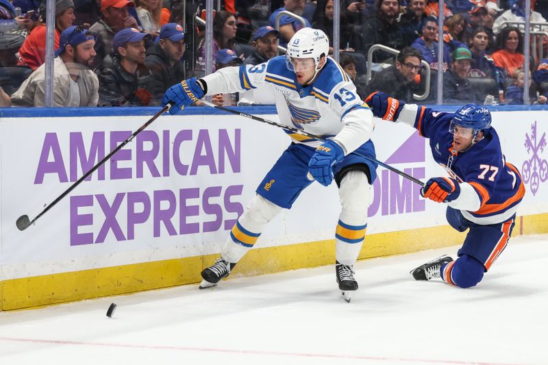 Nov 22, 2025; Elmont, New York, USA;  St. Louis Blues right wing Alexey Toropchenko (13) and New York Islanders defenseman Tony Deangelo (77) battle for control of the puck in the first period at UBS Arena. Mandatory Credit: Wendell Cruz-Imagn Images