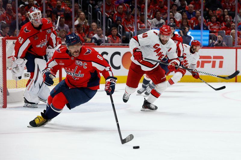 May 6, 2025; Washington, District of Columbia, USA; Washington Capitals left wing Alex Ovechkin (8) controls the puck in front of Capitals goaltender Logan Thompson (48) as Carolina Hurricanes left wing Jordan Martinook (48) chases in the second period in game one of the second round of the 2025 Stanley Cup Playoffs at Capital One Arena. Mandatory Credit: Geoff Burke-Imagn Images