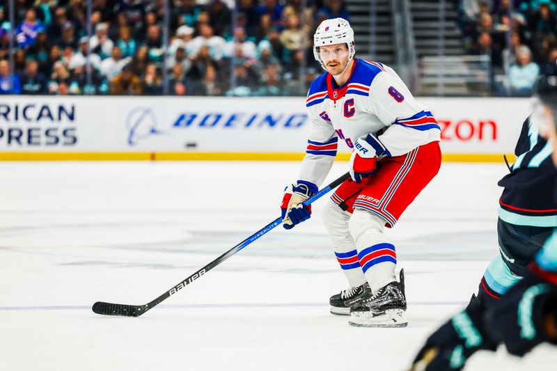 Nov 17, 2024; Seattle, Washington, USA; New York Rangers defenseman Jacob Trouba (8) looks to pass against the Seattle Kraken during the second period at Climate Pledge Arena. Mandatory Credit: Joe Nicholson-Imagn Images