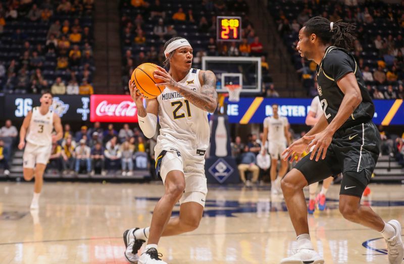 Feb 20, 2024; Morgantown, West Virginia, USA; West Virginia Mountaineers guard RaeQuan Battle (21) drives to the basket during the second half against the UCF Knights at WVU Coliseum. Mandatory Credit: Ben Queen-USA TODAY Sports