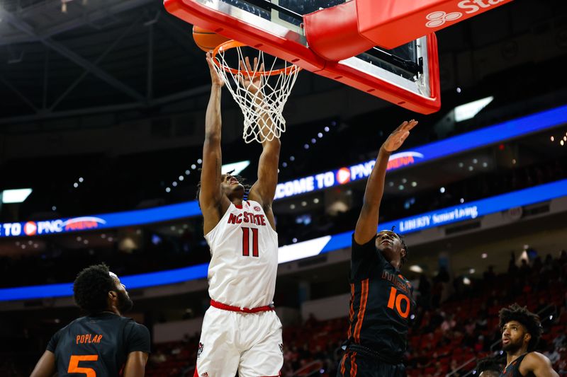 Jan 30, 2024; Raleigh, North Carolina, USA; North Carolina State Wolfpack guard Dennis Parker Jr. (11) dunks the ball during the first half against Miami (Fl) Hurricanes at PNC Arena. Mandatory Credit: Jaylynn Nash-USA TODAY Sports