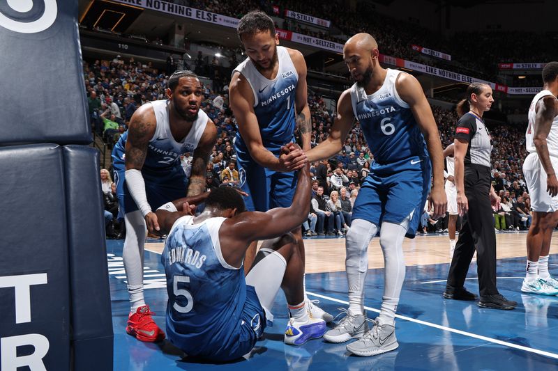 MINNEAPOLIS, MN -  MARCH 22: Anthony Edwards #5 of the Minnesota Timberwolves is helped up by teammates during the game against the Cleveland Cavaliers on March 22, 2024 at Target Center in Minneapolis, Minnesota. NOTE TO USER: User expressly acknowledges and agrees that, by downloading and or using this Photograph, user is consenting to the terms and conditions of the Getty Images License Agreement. Mandatory Copyright Notice: Copyright 2024 NBAE (Photo by David Sherman/NBAE via Getty Images)