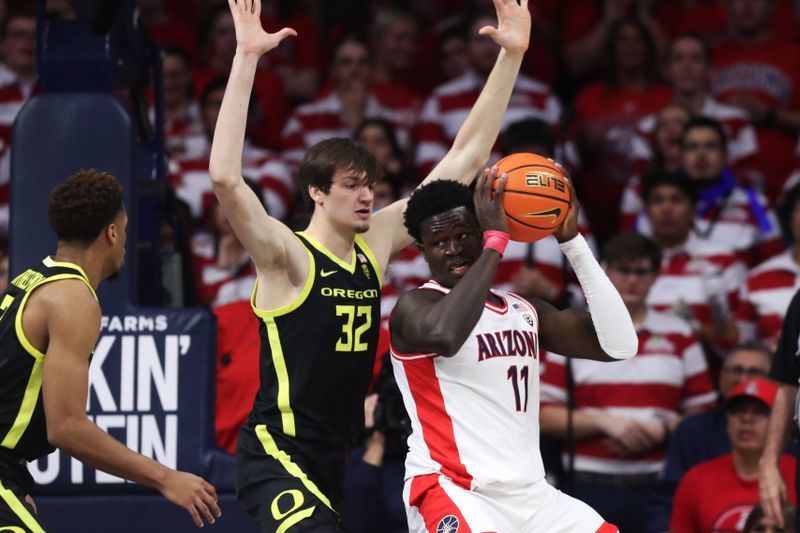 Feb 2, 2023; Tucson, Arizona, USA; Arizona Wildcats center Oumar Ballo (11) fights for room to shoot against Oregon Ducks center Nate Bittle (32)  in the first hall at McKale Center. Mandatory Credit: Zachary BonDurant-USA TODAY Sports