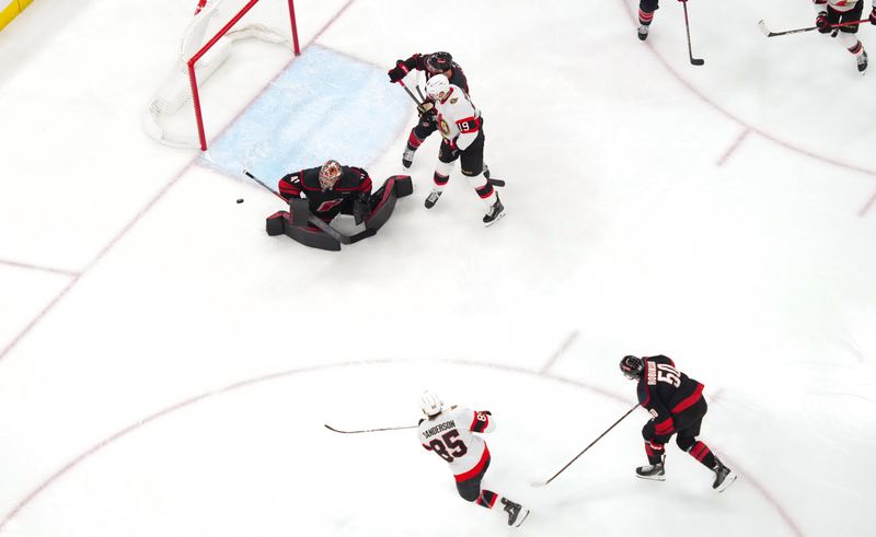 Nov 16, 2024; Raleigh, North Carolina, USA;  Carolina Hurricanes goaltender Frederik Andersen (31) stops the shot by Ottawa Senators defenseman Jake Sanderson (85) during the third period at Lenovo Center. Mandatory Credit: James Guillory-Imagn Images