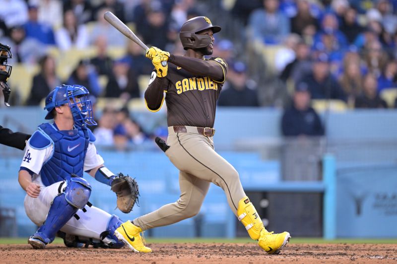 Apr 14, 2024; Los Angeles, California, USA; San Diego Padres outfielder Jurickson Profar (10) hits a three run double in the seventh inning against the Los Angeles Dodgers at Dodger Stadium. Mandatory Credit: Jayne Kamin-Oncea-USA TODAY Sports