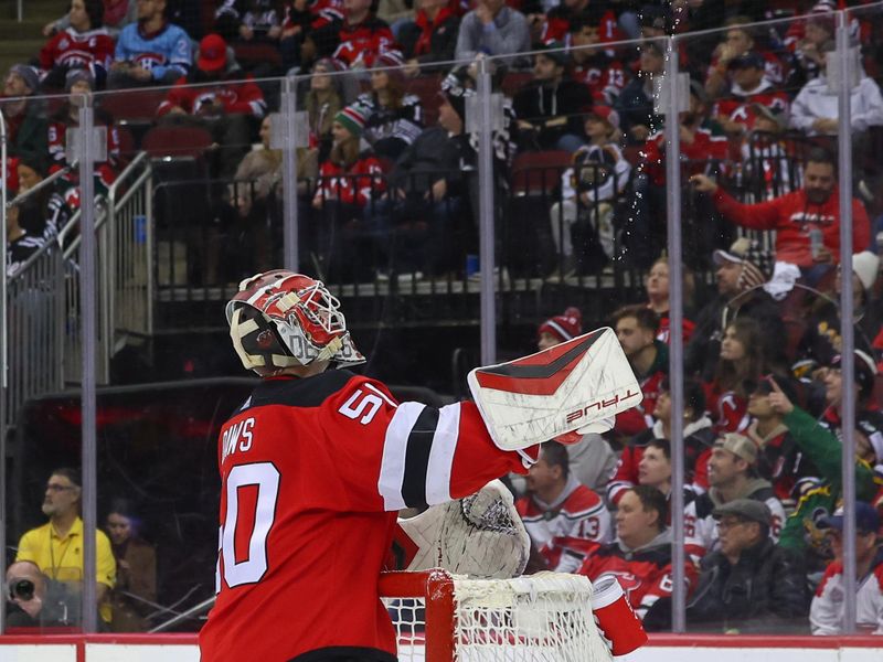 Jan 17, 2024; Newark, New Jersey, USA; New Jersey Devils goaltender Nico Daws (50) squirts water in the air during a break in the third period against the Montreal Canadiens at Prudential Center. Mandatory Credit: Ed Mulholland-USA TODAY Sports