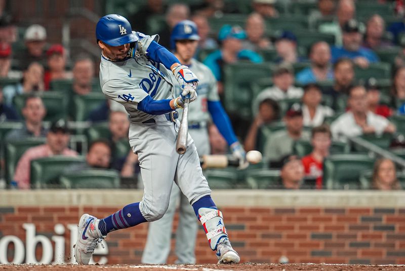 Sep 15, 2024; Cumberland, Georgia, USA; Los Angeles Dodgers right fielder Mookie Betts (21) singles to drive in a run against the Atlanta Braves during the ninth inning at Truist Park. Mandatory Credit: Dale Zanine-Imagn Images