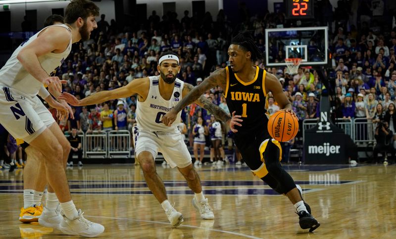 Feb 19, 2023; Evanston, Illinois, USA; Northwestern Wildcats guard Boo Buie (0) defends Iowa Hawkeyes guard Ahron Ulis (1) during the first half at Welsh-Ryan Arena. Mandatory Credit: David Banks-USA TODAY Sports