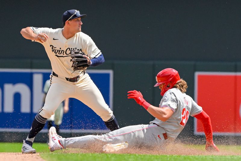 Jul 24, 2024; Minneapolis, Minnesota, USA;  Minnesota Twins infielder Brooks Lee (72) throws over Philadelphia Phillies infielder Alec Bohm (28) after forcing him out by during the seventh inning at Target Field. Mandatory Credit: Nick Wosika-USA TODAY Sports