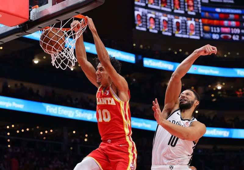 ATLANTA, GEORGIA - OCTOBER 23:  Zaccharie Risacher #10 of the Atlanta Hawks dunks against Ben Simmons #10 of the Brooklyn Nets during the third quarter at State Farm Arena on October 23, 2024 in Atlanta, Georgia.  NOTE TO USER: User expressly acknowledges and agrees that, by downloading and/or using this photograph, user is consenting to the terms and conditions of the Getty Images License Agreement.  (Photo by Kevin C. Cox/Getty Images)