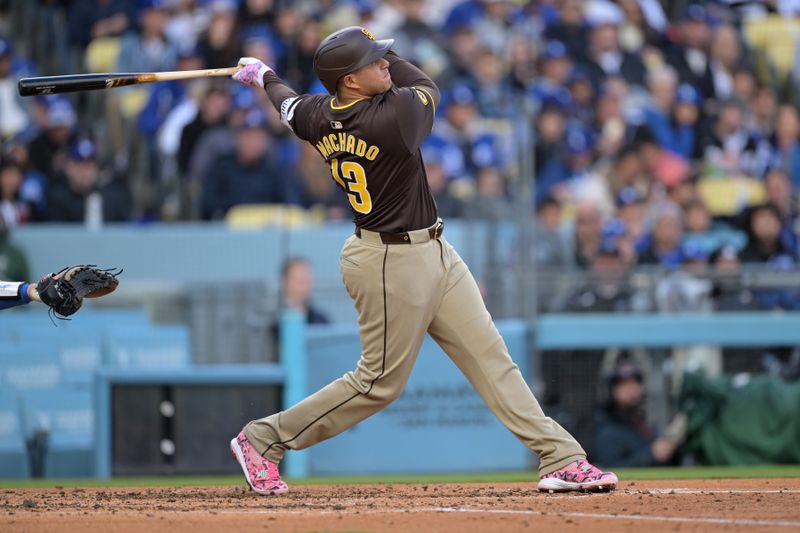 Apr 14, 2024; Los Angeles, California, USA; San Diego Padres third base Manny Machado (13) hits a solo home run in the fourth inning against the Los Angeles Dodgers at Dodger Stadium. Mandatory Credit: Jayne Kamin-Oncea-USA TODAY Sports