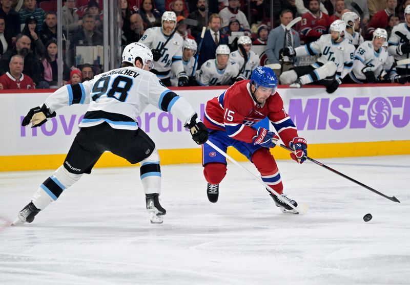 Nov 8, 2025; Montreal, Quebec, CAN; Montreal Canadiens forward Alex Newhook (15) plays the puck and Utah Mammoth defenseman Mikhail Sergachev (98) defends during the first period at the Bell Centre. Mandatory Credit: Eric Bolte-Imagn Images