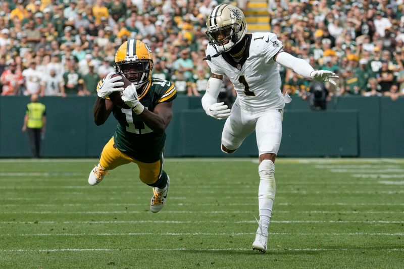 Green Bay Packers wide receiver Jayden Reed (11) pulls in a first down catch against New Orleans Saints cornerback Alontae Taylor (1) during the second half of an NFL football game Sunday, Sept. 24, 2023, in Green Bay, Wis. (AP Photo/Morry Gash)