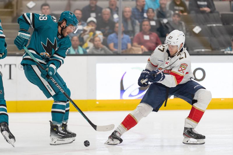 Nov 14, 2023; San Jose, California, USA; San Jose Sharks left wing Mike Hoffman (68) and Florida Panthers center Eetu Luostarinen (27) fight for control of the puck during the second period at SAP Center at San Jose. Mandatory Credit: Stan Szeto-USA TODAY Sports