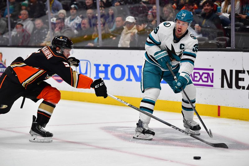 Jan 31, 2024; Anaheim, California, USA; San Jose Sharks center Logan Couture (39) moves the puck against Anaheim Ducks defenseman Urho Vaakanainen (5) during the first period at Honda Center. Mandatory Credit: Gary A. Vasquez-USA TODAY Sports