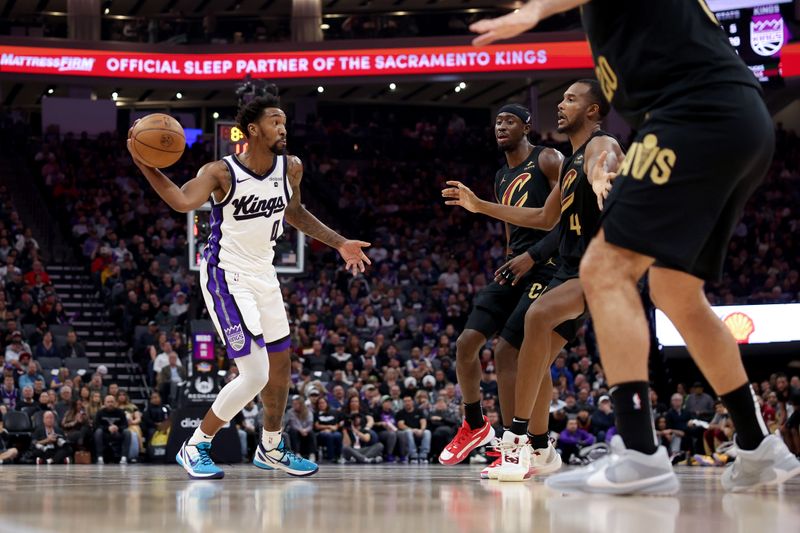 SACRAMENTO, CALIFORNIA - NOVEMBER 13: Malik Monk #0 of the Sacramento Kings looks to pass around Evan Mobley #4 of the Cleveland Cavaliers in the first half at Golden 1 Center on November 13, 2023 in Sacramento, California. NOTE TO USER: User expressly acknowledges and agrees that, by downloading and or using this photograph, User is consenting to the terms and conditions of the Getty Images License Agreement.  (Photo by Ezra Shaw/Getty Images)