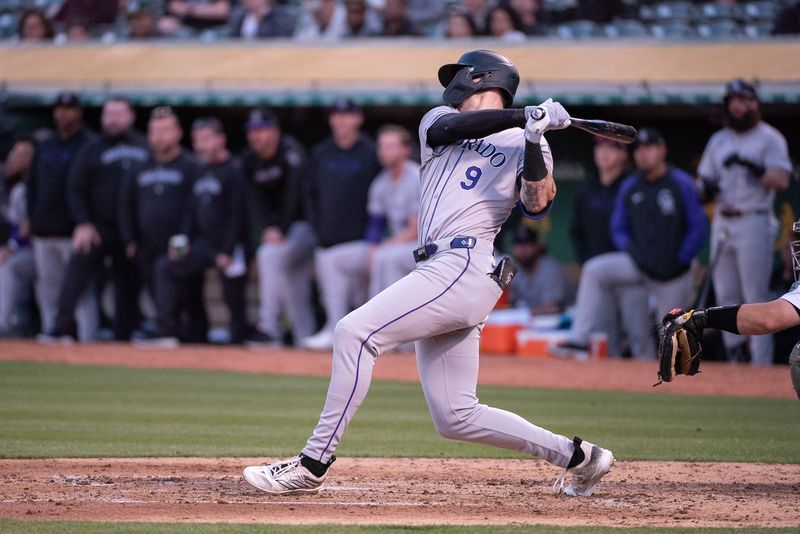 May 21, 2024; Oakland, California, USA; Colorado Rockies outfielder Brenton Doyle (9) hits a single against the Oakland Athletics during the sixth inning at Oakland-Alameda County Coliseum. Mandatory Credit: Ed Szczepanski-USA TODAY Sports